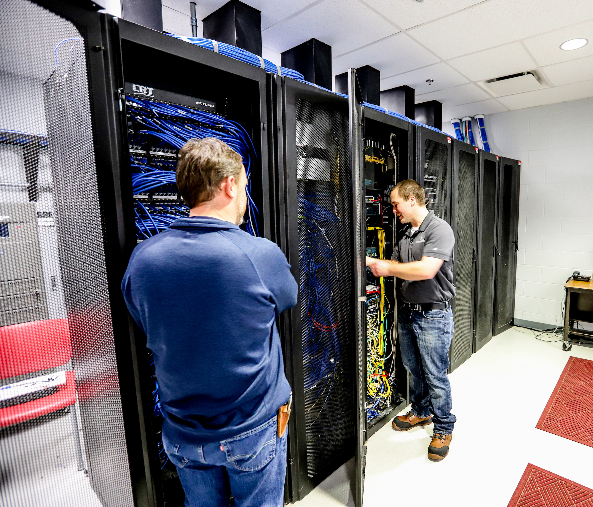 Technology Technicians Working on Server Cabinets